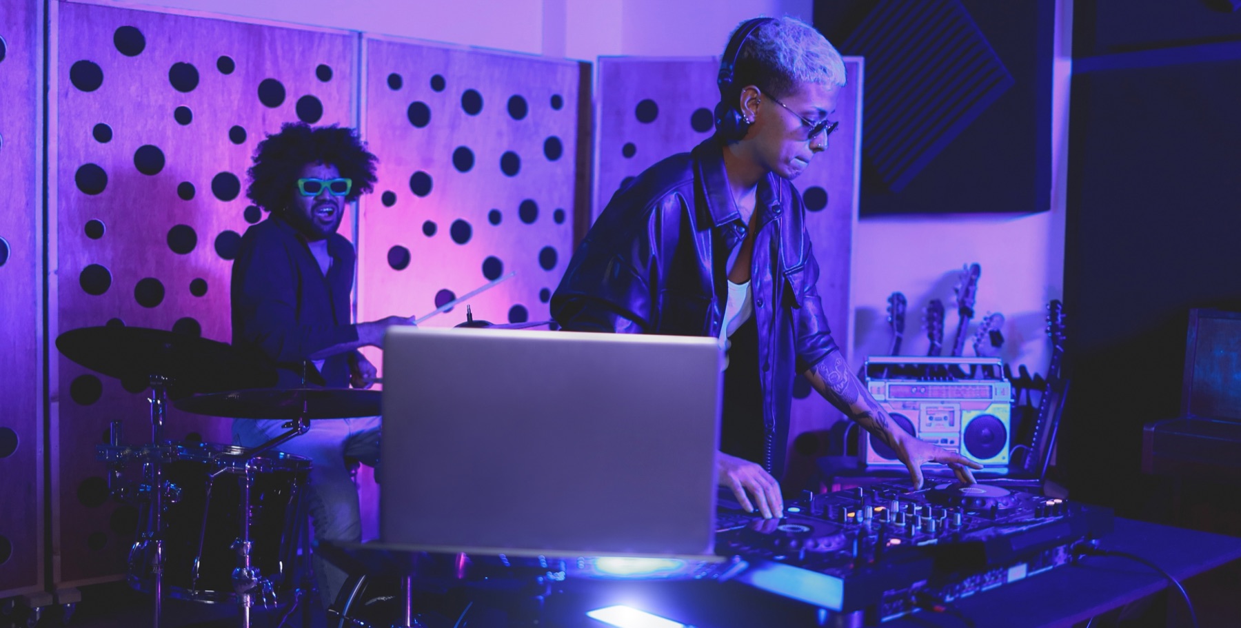 DJ and drummer performing together in a studio